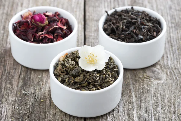 Assorted dry herbal teas in white bowls — Stock Photo, Image