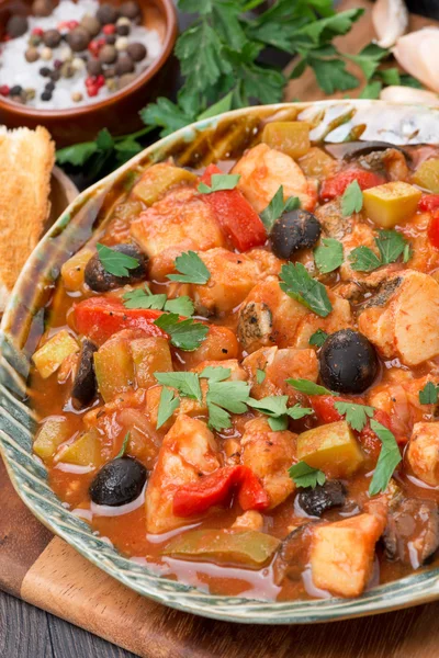 Guiso de pescado con aceitunas en salsa de tomate en un plato, vertical — Foto de Stock