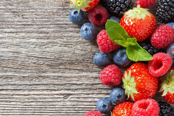 Wooden background with fresh berries and mint — Stock Photo, Image