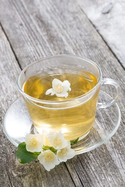 Cup of green tea with jasmine on wooden background — Stock Photo, Image