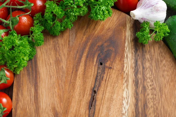 Dřevěná deska pozadí, čerstvá rajčata a bylinky — Stock fotografie