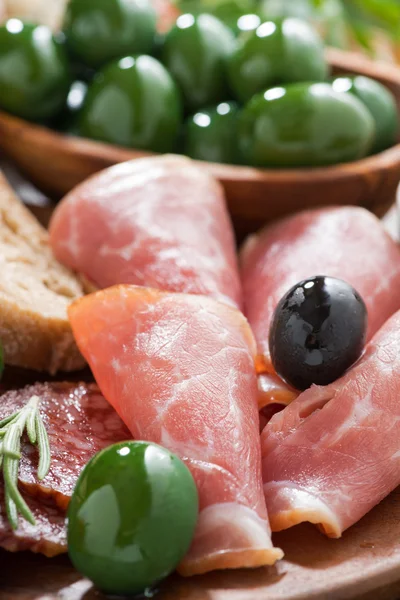 Geassorteerde Italiaanse antipasti - vleeswaren, olijven en ciabatta — Stockfoto