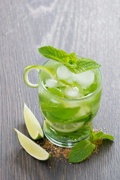 Mojito cocktail med lime och mynta på träbord, vertikal — Stockfoto