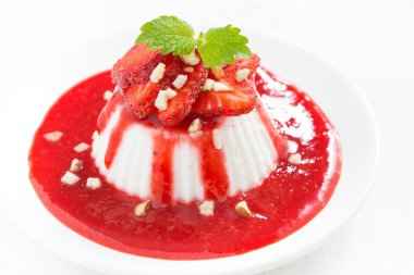 Vanilla panna cotta bir tabakta üstten görünüm çilek sosu ile