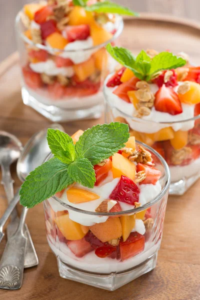 Fruit dessert with whipped cream, mint and granola, top view — Stock Photo, Image