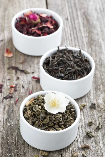 Různé suché bylinné čaje v bílých misek, vertikální — Stock fotografie