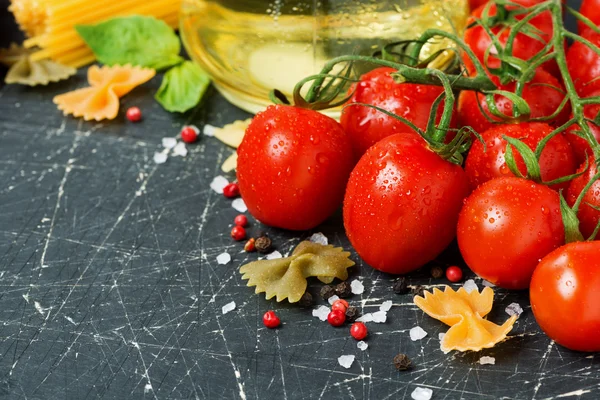 Fundo escuro com tomates cereja e ingredientes — Fotografia de Stock