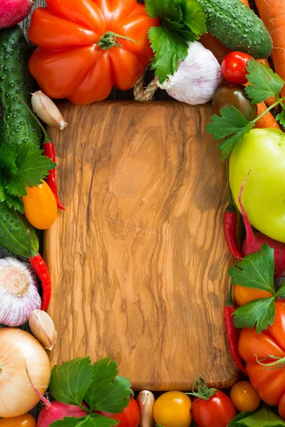 Dřevěná deska pro recept a čerstvá zelenina, pohled shora — Stock fotografie