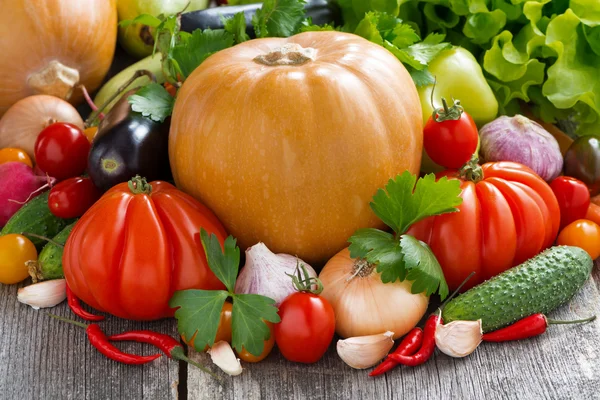 Cosecha de verduras frescas de temporada sobre un fondo de madera — Foto de Stock