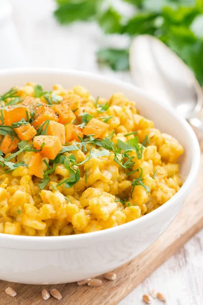 Barley porridge with pumpkin and greens in a bowl, close-up — Stock Photo, Image