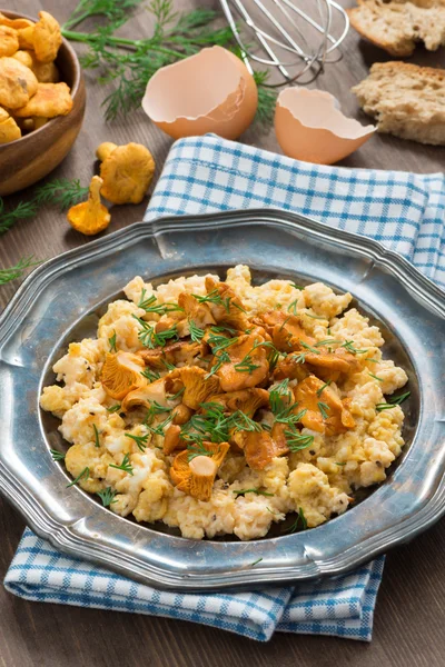 Scrambled eggs with chanterelles and fresh dill on a plate — Stock Photo, Image