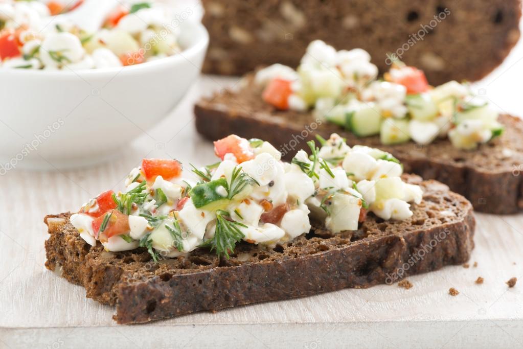 Rye bread with cheese and vegetables, close-up
