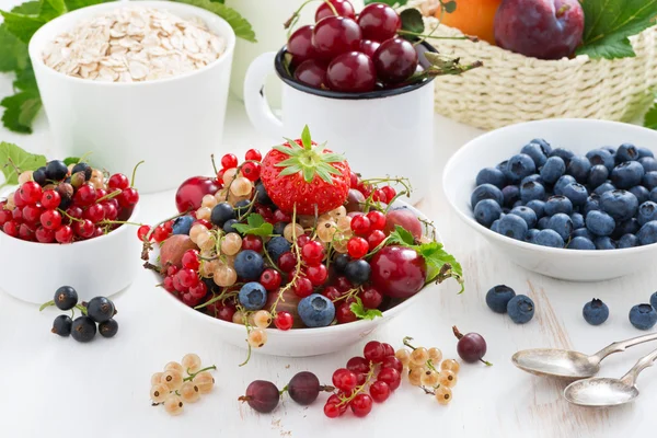 Harvest of fresh berries and fruits on white wooden table — Stock Photo, Image