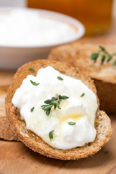 Tostadas con queso de cabra, miel y tomillo sobre tabla de madera — Foto de Stock