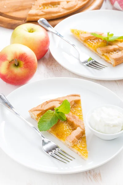 Piece of fresh apple pie with whipped cream on a plate, top view — Stock Photo, Image