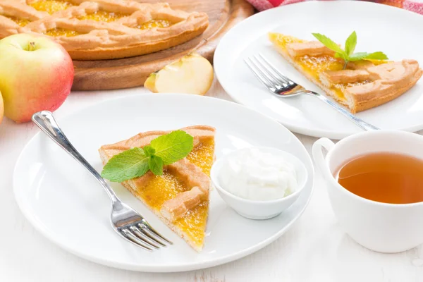 Piece of fresh apple pie with whipped cream and cup of tea — Stock Photo, Image