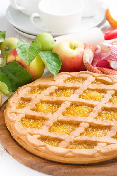 Round apple pie on a white wooden table, vertical — Stock Photo, Image