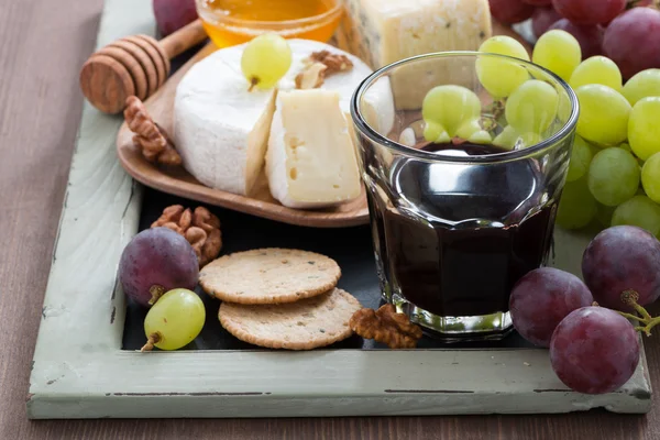 Verschiedene Vorspeisen zu Wein - Käse, Trauben, Cracker — Stockfoto