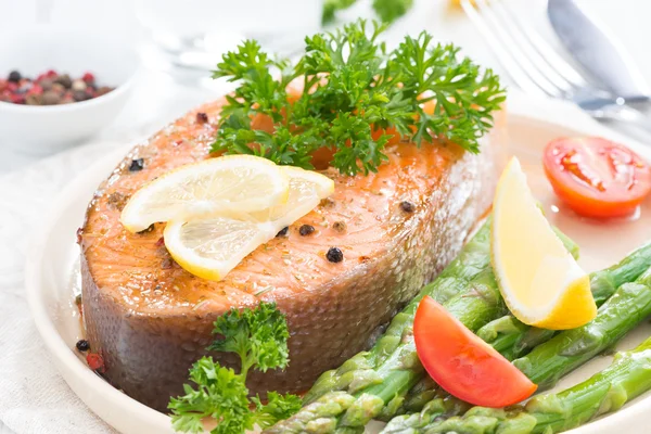 Baked salmon with asparagus, parsley and lemon, close-up — Stock Photo, Image