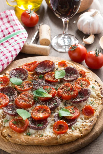 Italiensk mat - pizza med salami och tomat, glas vin — Stockfoto