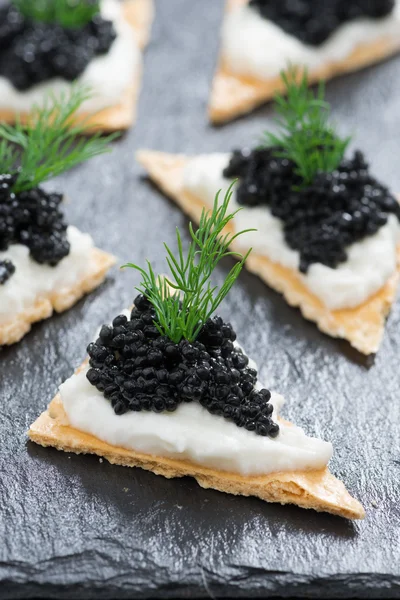 Biscoitos com queijo creme e caviar preto, vertical — Fotografia de Stock