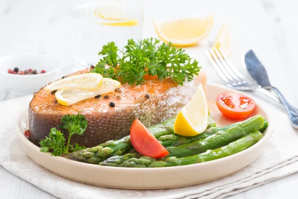 Gebackener Lachs mit Spargel und Zitrone auf Teller — Stockfoto