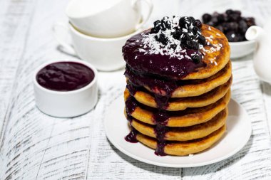 stack of corn pancakes with blueberry jam for breakfast, horizontal