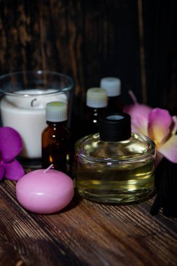 Kaplıca tedavilerinin özellikleri - mumlar, aroma yayıcı ve ahşap arka planda aroma yağları, yakın plan