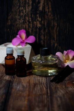 Beton bir kapta mum ve ahşap arka planda aroma yayıcı, dikey yakın plan