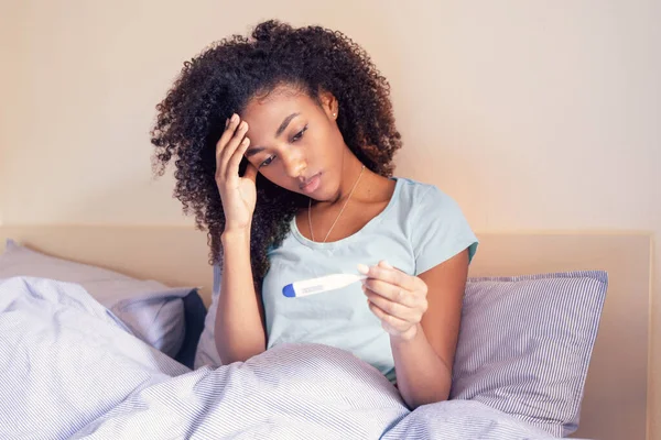 Sjuk Afro Kvinna Liggande Sängen Med Hög Feber Tittar Termometern — Stockfoto
