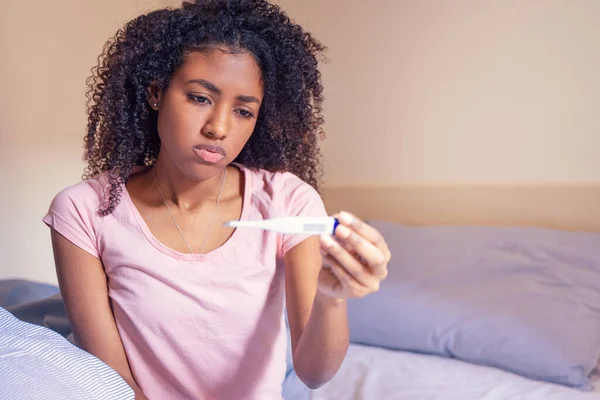 Sjuk Afro Kvinna Liggande Sängen Med Hög Feber Tittar Termometern — Stockfoto