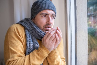 One man feeling cold at home after home heating trouble clipart