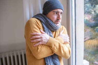 One man suffering cold at home and problem with house heating clipart