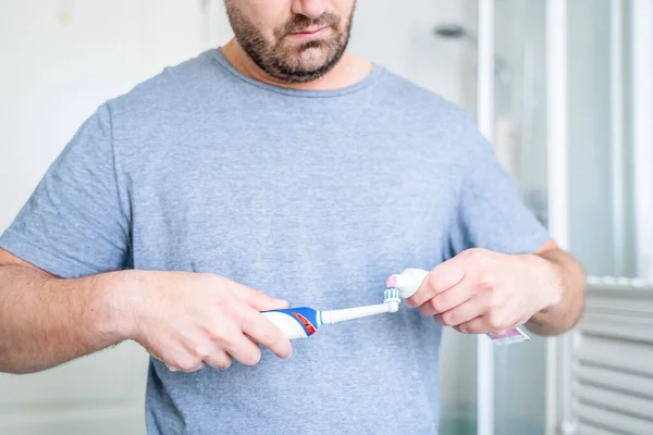 Muž Uvedení Zubní Pastu Elektrický Kartáček Koupelně — Stock fotografie