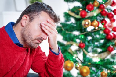 Endişeli bir adam Noel stresi ve endişesi yaşıyor.