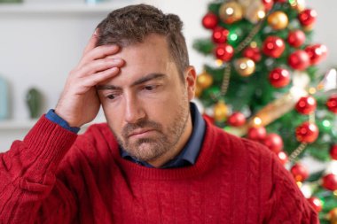 Endişeli bir adam Noel stresi ve endişesi yaşıyor.