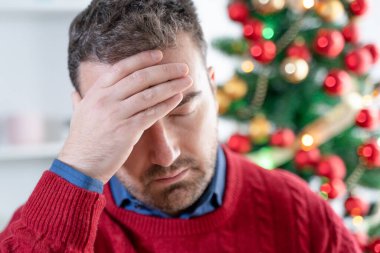 Endişeli bir adam Noel stresi ve endişesi yaşıyor.
