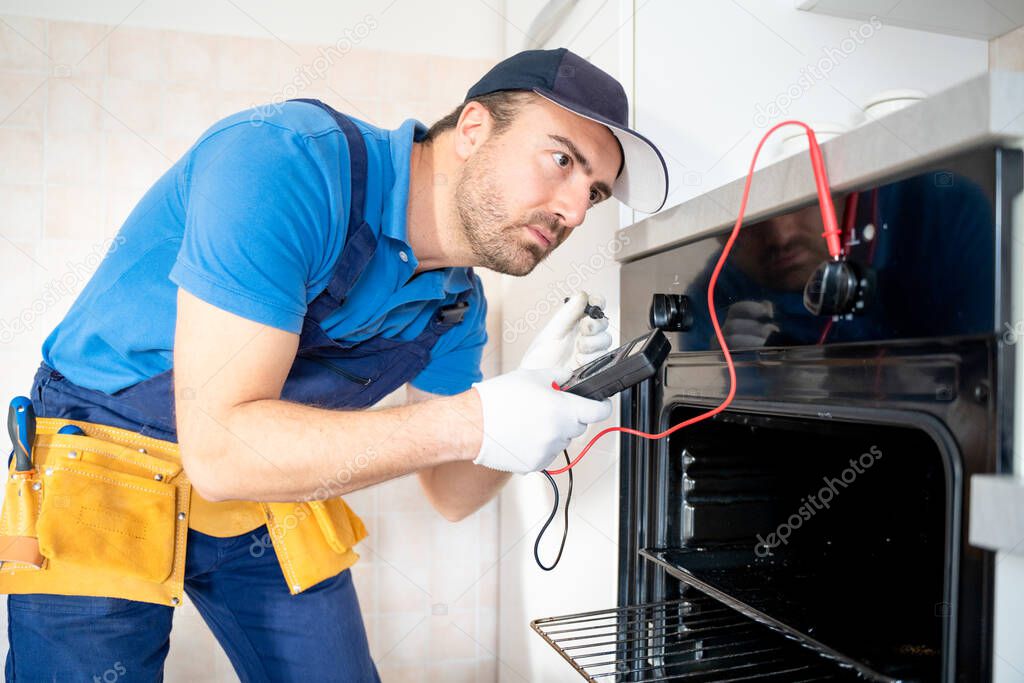 One expert repairman fixing a broken kitchen oven