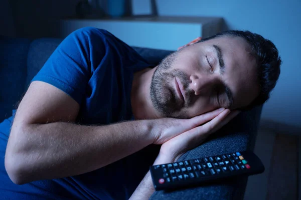 One man sleeping and snoring watching television