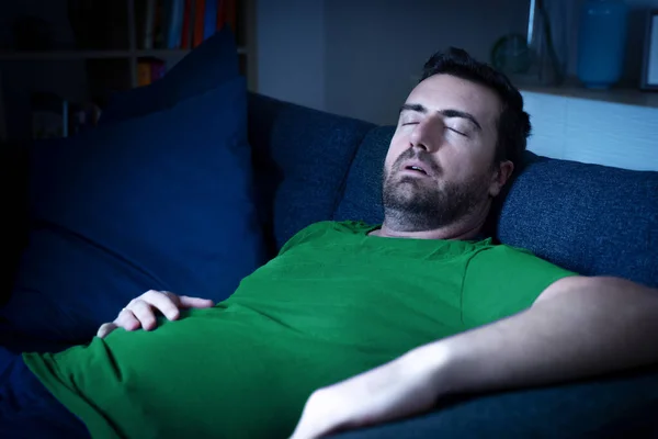 One man sleeping and snoring watching television