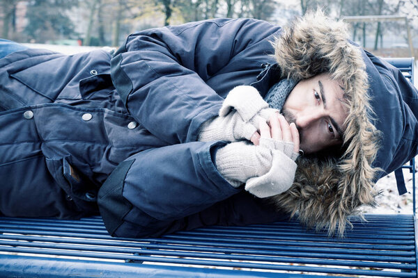 Poor homeless man suffering cold during winter weather season