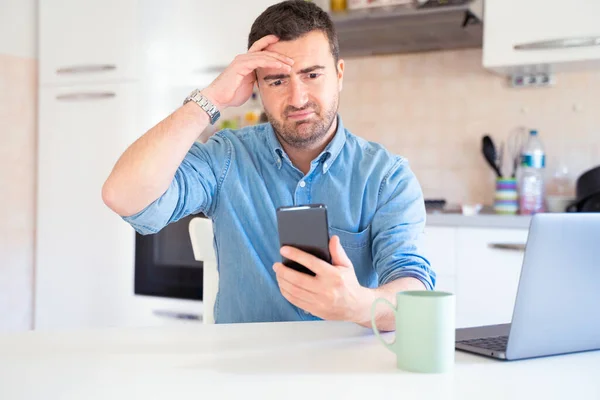 Worried and sad man looking at the mobile phone