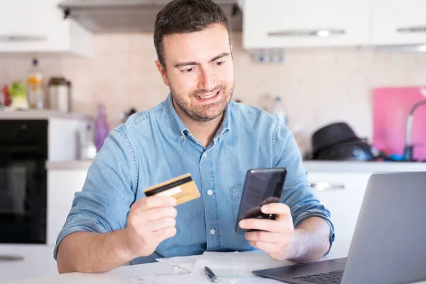 Homem Fazendo Compras Usando Telefone Cartão Crédito Casa — Fotografia de Stock