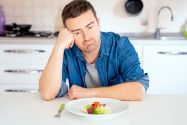 Bir adam diyet yapıyor ve sebze ve salatadan hoşlanmıyor.
