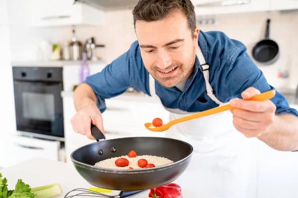 집에서 주방에서 요리하는 솜씨좋은 남자가 조미료를 맛보다 — 스톡 사진