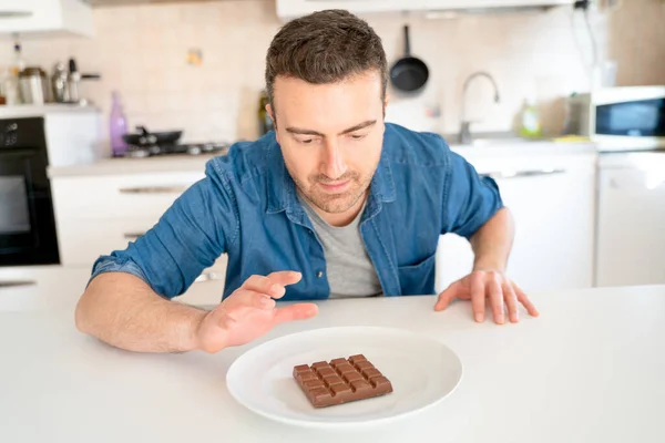 One man on diet tempted by chocolate sweet