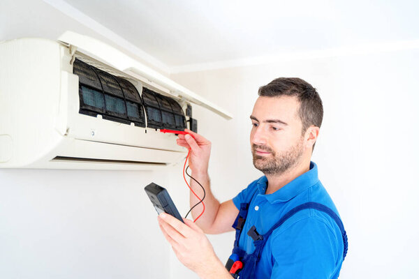 Technician installing air conditioner testing short circuit