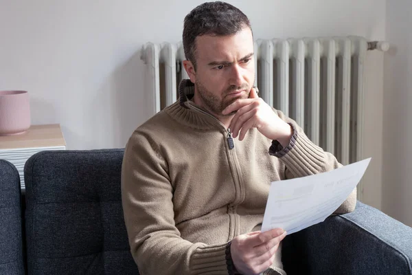 Shocked man reading some documents on sofa living room