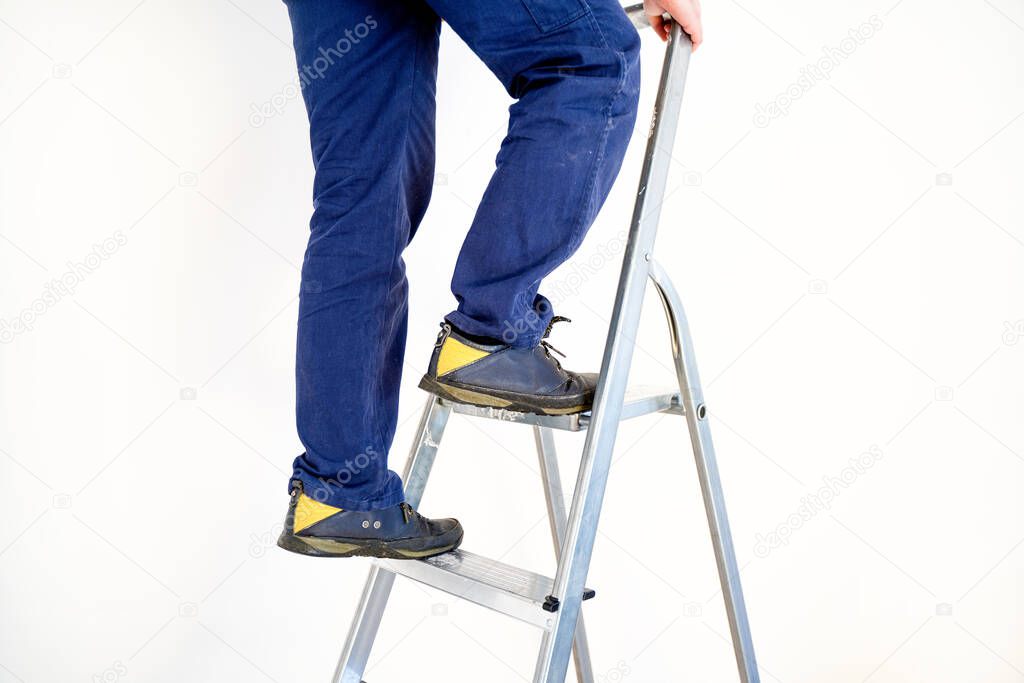 Accident at work prevention concept, worker feet on the ladder