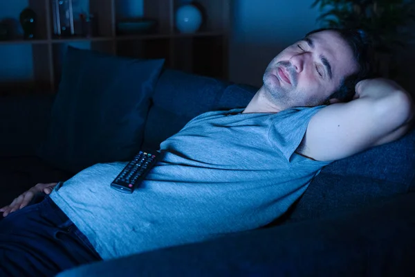 Man snoring and sleeping lying on the sofa at home